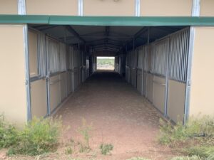 Barn aisle at Tiger Owl Ranch horse boarding facility in Santa Fe, New Mexico